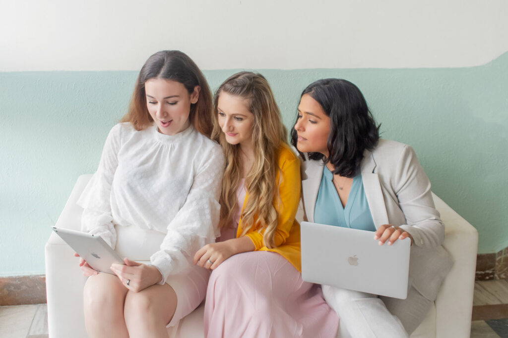 Group of Women on Sofa Using Laptop and Tablet