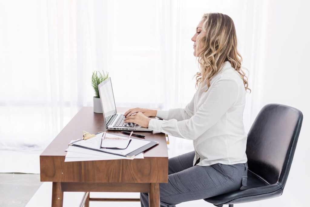 Woman using laptop at desk.