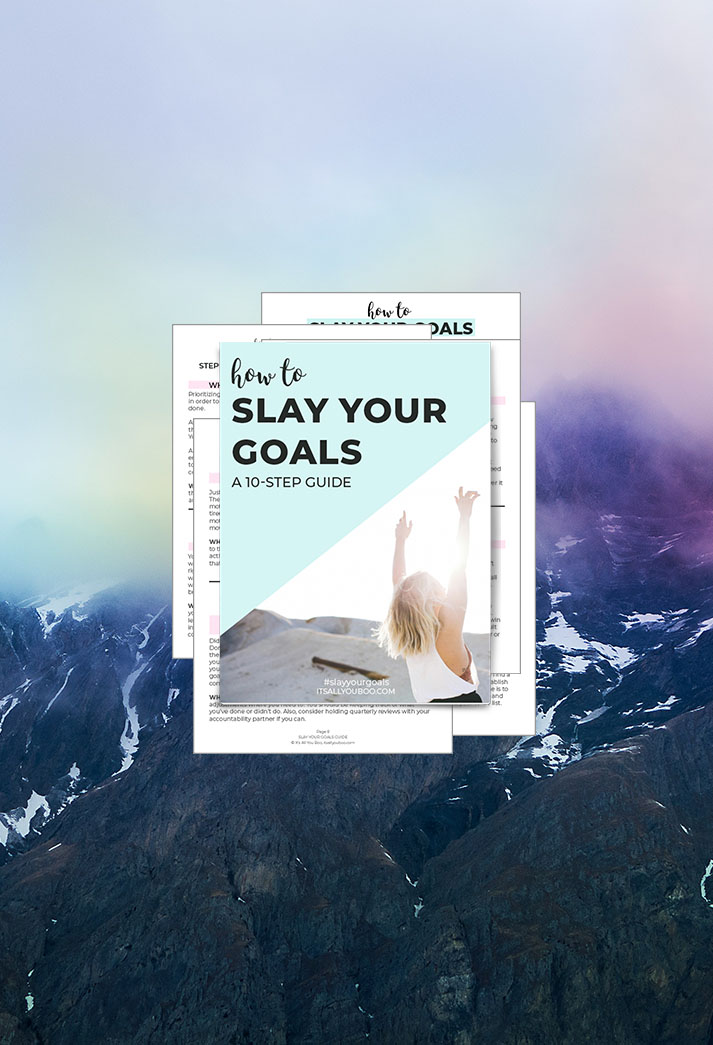 Slay Your Goals Guide Preview of Pages in front of a rainbow sky.