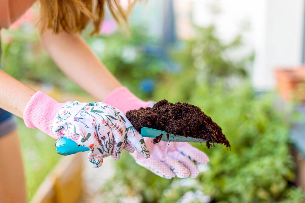 Woman Gardening Outside with hands holding dirt. Showing what to do in Springtime.