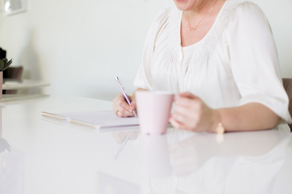 Woman Writing with Pink Mug.